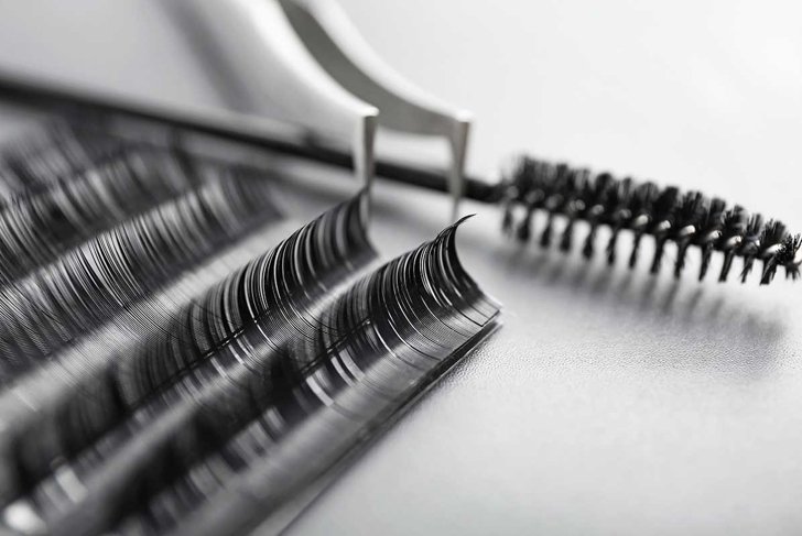 Set of eyelash extensions on grey background, closeup