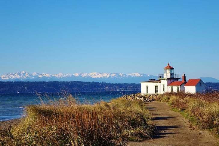 West Point Light is a lighthouse at Discovery Park in Seattle on Puget Sound's Elliott Bay. A hiking path leads to the lighthouse & beautiful view of snow capped Olympic Mountains on clear winter day.