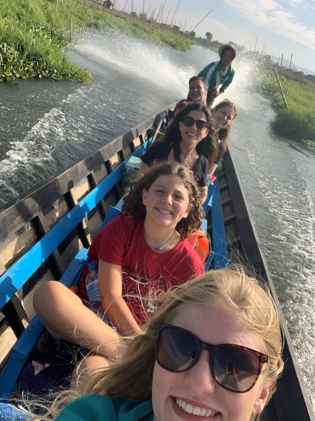 A family traveling full-time together posing in a motorized canoe