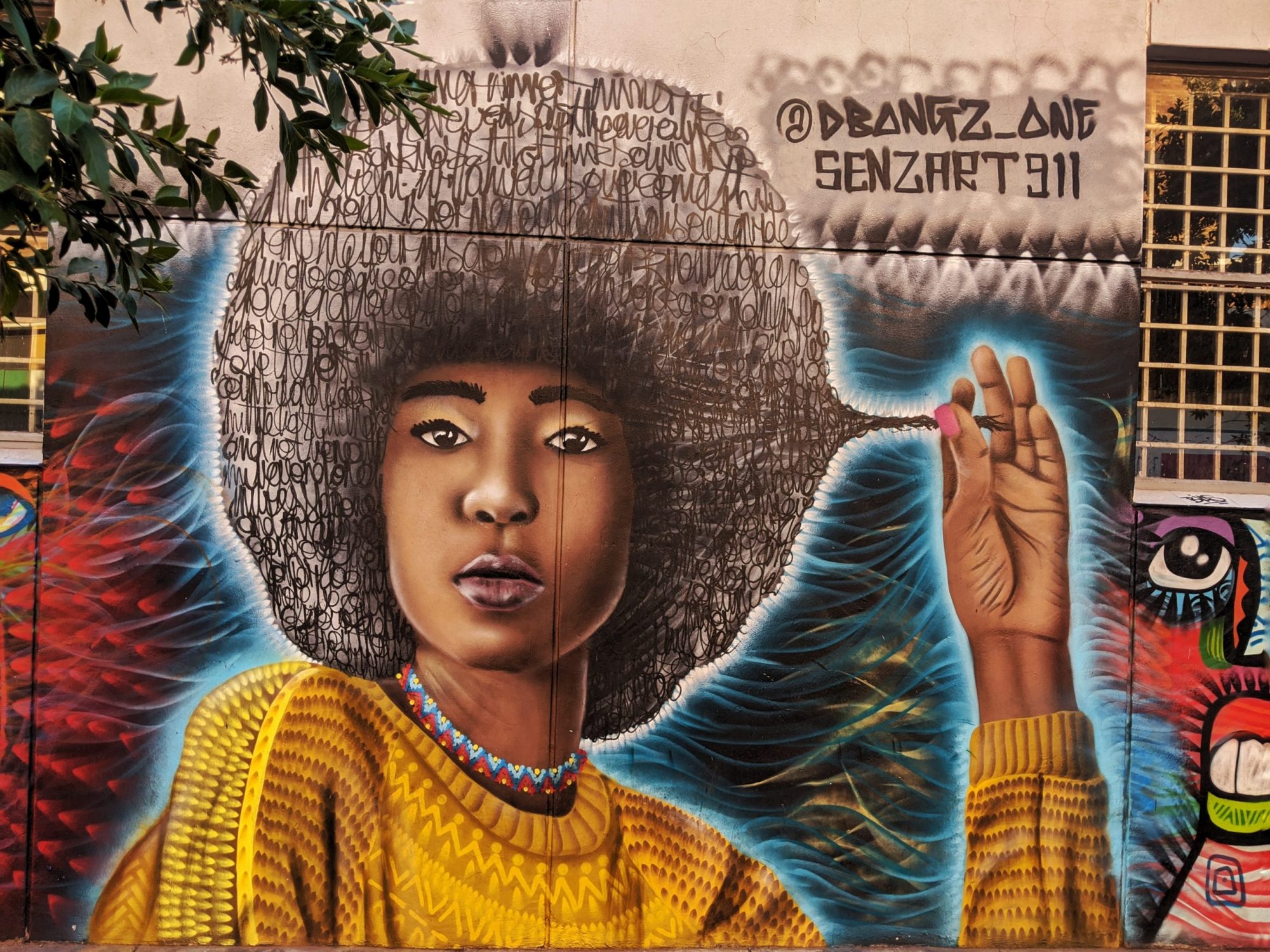 Street art portrait of a black woman with an afro in South Africa - unique destinations