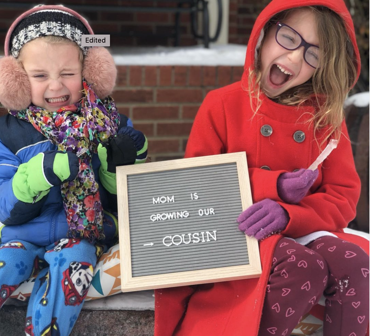 An image of Samson Stoner and Ruthie Stoner holding a sign for Cathey Stoner.